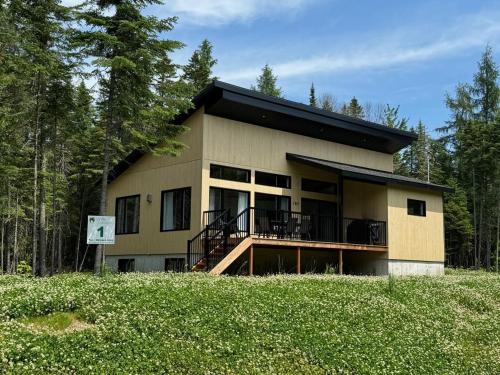 a house with a balcony in the middle of a field at Chalet Mirasol in Valcartier Station