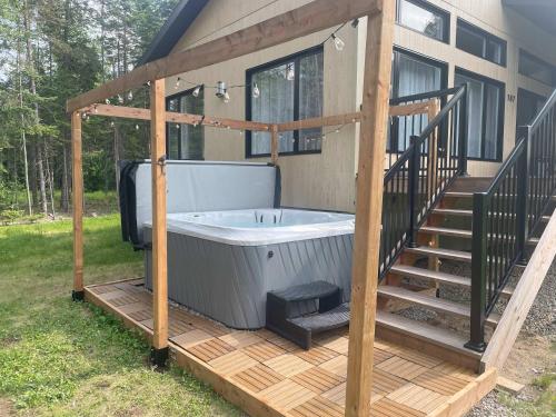 a hot tub on a deck next to a house at Chalet Mirasol in Valcartier Station