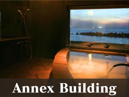 a bathroom with a tub with a large window at 越前の宿うおたけ in Echizen-shi