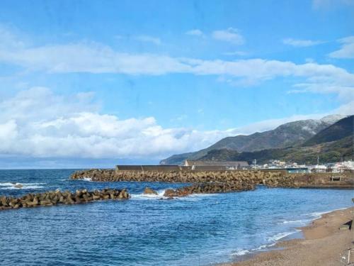 a beach with a bunch of rocks in the water at 越前の宿うおたけ in Echizen-shi