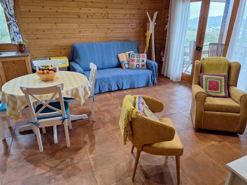 un soggiorno con tavolo, sedie e divano di Quinta da Pavoa - Cottage House a Vila Franca do Campo