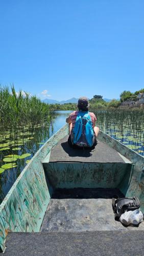 a person with a backpack sitting on a boat at Apartments Aerodrom in Podgorica