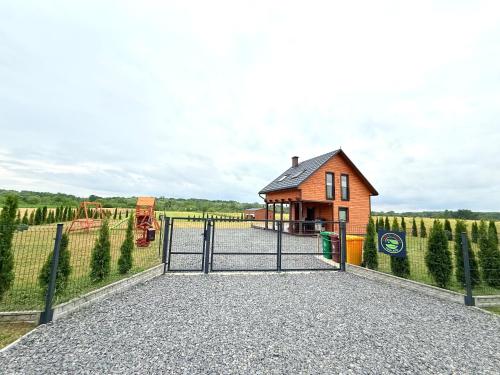a gate to a small house in a field at Green-Point Podlasie in Drohiczyn nad Bugiem
