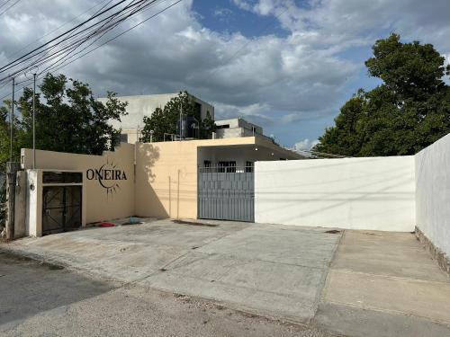 a white building with a gate and a fence at Oneira Seybaplaya apartments private and exclusive in Seybaplaya
