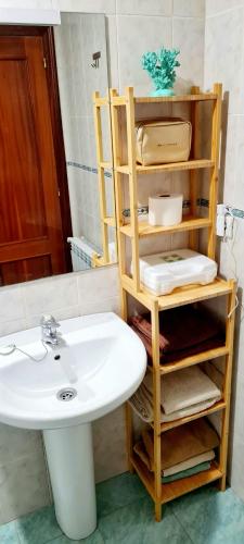 a bathroom with a white sink and a white sink at Bajo con jardin Costa Quebrada in Liencres