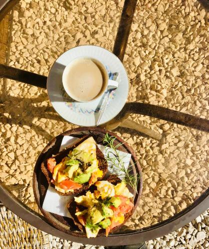 a table with a plate of food and a cup of coffee at Forest Glam in San Andrés de Giles