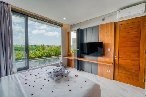 a bedroom with a bed and a large window at Bhumi Villas 2BR Ricefield View in Canggu in Munggu