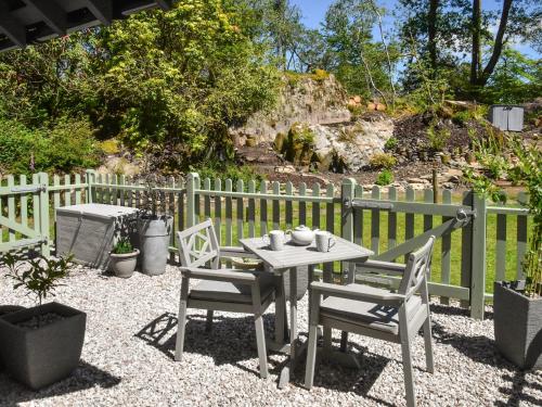 a table and chairs sitting on a gravel patio at Holly Hideaway - Cottage in Troutbeck Bridge