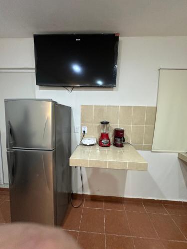 a kitchen with a stainless steel refrigerator and a tv at Oneira Seybaplaya apartments private and exclusive in Seybaplaya