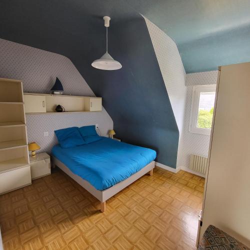- une chambre avec un lit bleu dans l'établissement La Familiale de Kerambigorn, à Fouesnant