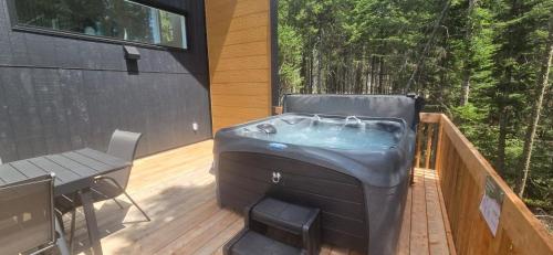 een hot tub op het terras van een huis bij Chalet Odin - SPA, PISCINE, SAUNA partagés in Valcartier Station