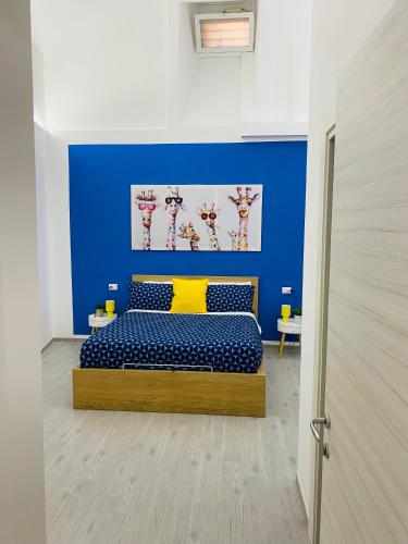 a room with a bed with a blue wall at Napoli Centro Casa Vacanza in Naples