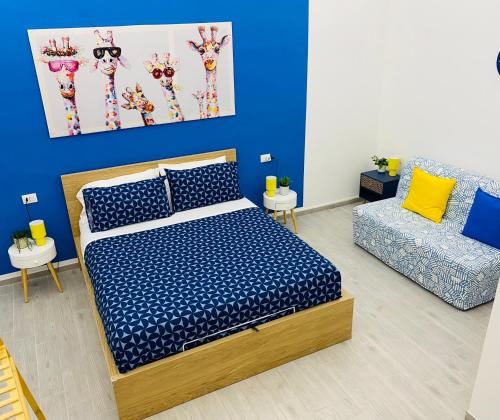 a blue bedroom with a bed and a couch at Napoli Centro Casa Vacanza in Naples