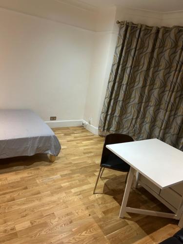 a bedroom with a bed and a desk and a table at Flat in Moffat