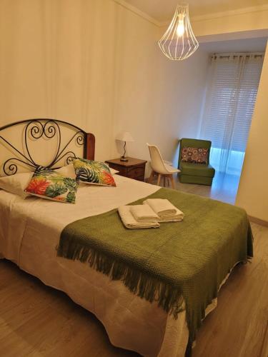 a bedroom with a bed with a green blanket at Home Aveiro Ria in Aveiro