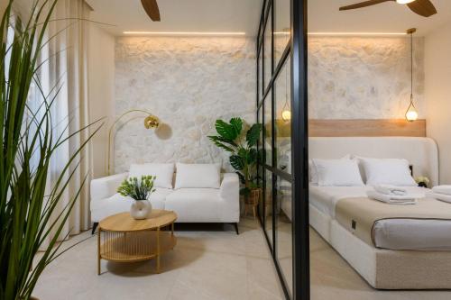 a bedroom with a white bed and a couch at Sentio Thassos Suites in Limenas