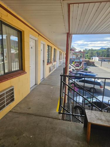 a building with a bench next to a parking lot at Camaray Motel in Oroville