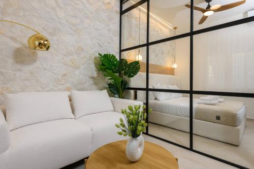 a living room with a white couch and a table at Sentio Thassos Suites in Limenas