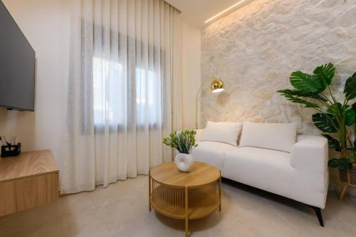 a living room with a white couch and a table at Sentio Thassos Suites in Limenas