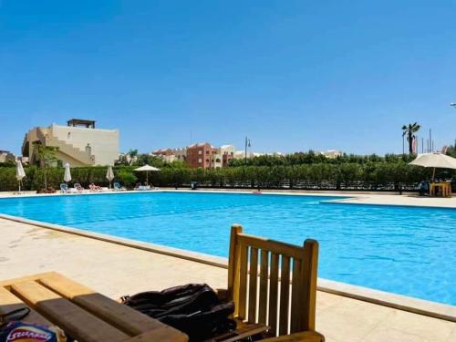 a bench next to a large swimming pool at Cecilia Resort in Hurghada