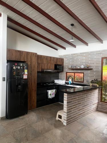 a kitchen with a black refrigerator and a counter at Casa de Campo Moderna Ubaté - Sector La Laja in Ubaté