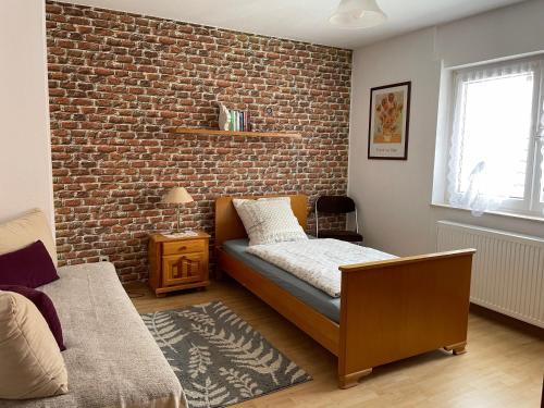 a bedroom with a brick wall and a bed at Ferienwohnung Amöneburg In Amöneburg in Amöneburg