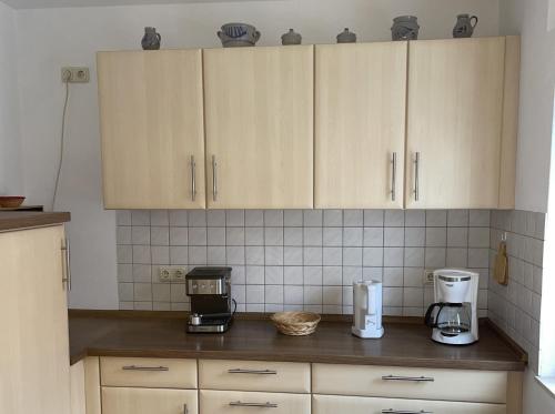 a kitchen with wooden cabinets and a coffee maker on the counter at Ferienwohnung Amöneburg In Amöneburg in Amöneburg