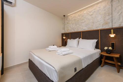 a bedroom with a large bed with towels on it at Sentio Thassos Suites in Limenas