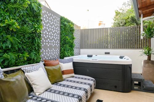 a patio with a hot tub and a couch at Sentio Thassos Suites in Limenas