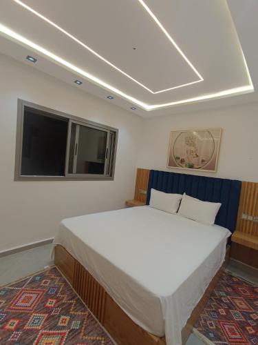 a bedroom with a large white bed and a flat screen tv at BlueSea Studio's &Appart in Oualidia