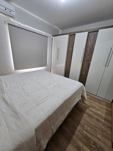 a bedroom with a large bed and white cabinets at Apartamento Inteiro Próximo ao Empório in Toledo