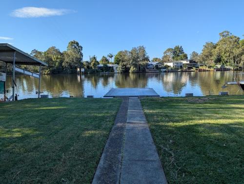a walkway next to a body of water at Reel Relax Retreat at Dora Creek in Dora Creek