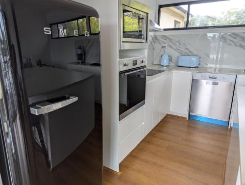 a kitchen with a sink and a dishwasher at Reel Relax Retreat at Dora Creek in Dora Creek