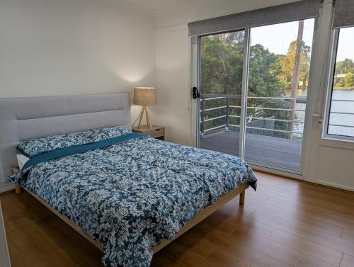 a bedroom with a bed and a sliding glass door at Reel Relax Retreat at Dora Creek in Dora Creek