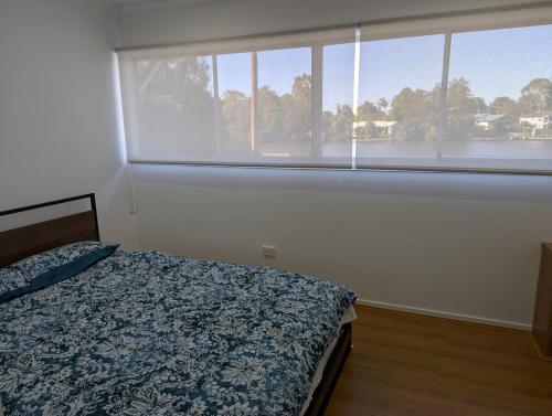 a bedroom with a bed and a large window at Reel Relax Retreat at Dora Creek in Dora Creek
