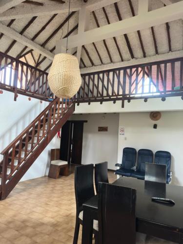 a meeting room with a table and chairs and a staircase at Hacienda Ecoturistica la libertad in Moniquirá