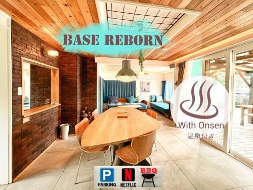 a large room with a wooden table and a couch at Base Reborn in Shiraoi