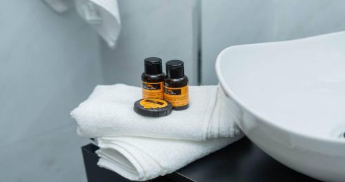 two bottles of essential oils sitting on towels next to a sink at Casa Comfort Moderne 1BR Apartment Stay in 2Mars in Casablanca