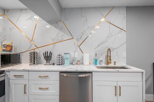 a kitchen with white cabinets and a stainless steel dishwasher at Quirky Museum District Apartment in Prime Location in Houston