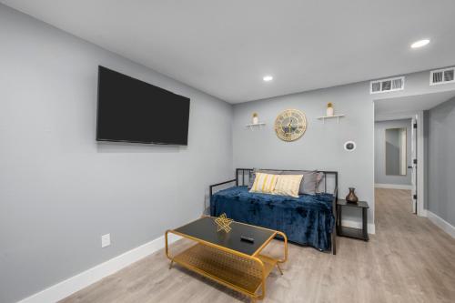 a bedroom with a bed and a tv on the wall at Quirky Museum District Apartment in Prime Location in Houston
