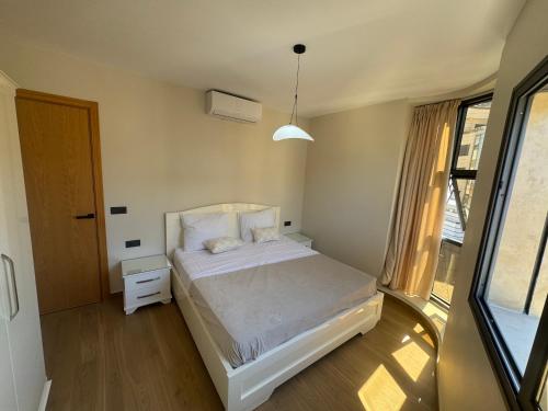 a bedroom with a white bed and a window at Belle cote appartement al hoceima in Al Hoceïma