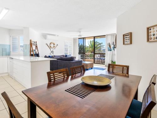 a dining room and kitchen with a table and chairs at Alexandria Apartments in Alexandra Headland