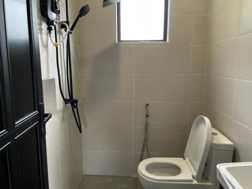 une salle de bain avec des toilettes blanches et une fenêtre dans l'établissement Pondok Selesa Homestay, à Shah Alam