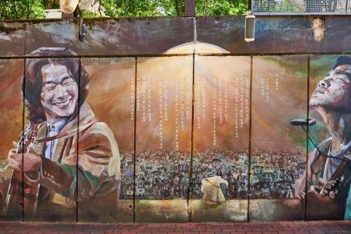 a wall with a painting of a group of people at STAY HARU in Daegu in Daegu