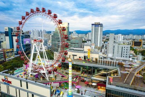 a carnival ferris wheel in a city with buildings at STAY HARU in Daegu in Daegu
