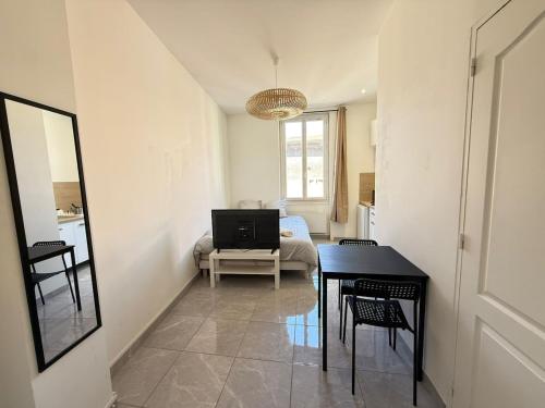 a living room with a table and a television at Studio Lune New & Cozy - Centre Vénissieux in Vénissieux