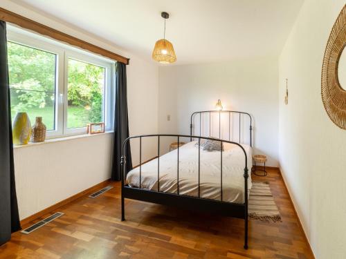 a bedroom with a bed and a window at Charming cottage in heart of the Ardennes in Lierneux