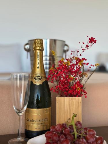 a bottle of wine next to a glass and flowers at Aqua Vista Monchique Hôtel in Monchique