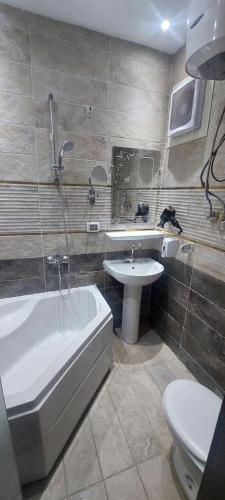 a bathroom with a tub and a sink and a toilet at Enter Pyramids Inn in Cairo