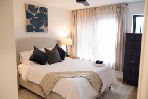 a bedroom with a white bed and a window at NEW! LUX 4BR + Rooftop | Parking | Metro in Washington, D.C.
